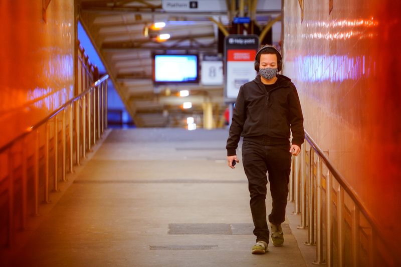 &copy; Reuters. FILE PHOTO: A lone passenger wearing a protective face mask walks from a deserted train platform at Flinders Street during morning commute hours on the first day of a lockdown as the state of Victoria looks to curb the spread of a coronavirus disease (COV