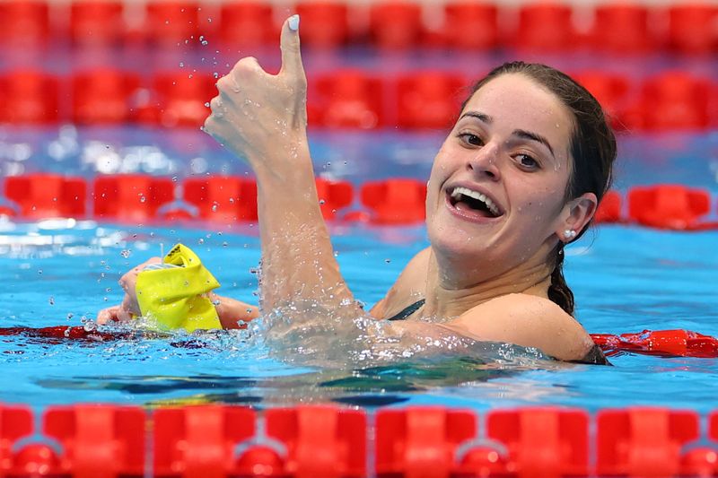 © Reuters. الأسترالية كايلي ماكيون بعد فوزها بالمركز الأول خلال سباق 100 متر ظهرا للسيدات في السباحة بألعاب طوكيو 2020 يوم الثلاثاء. صورة لرويترز.