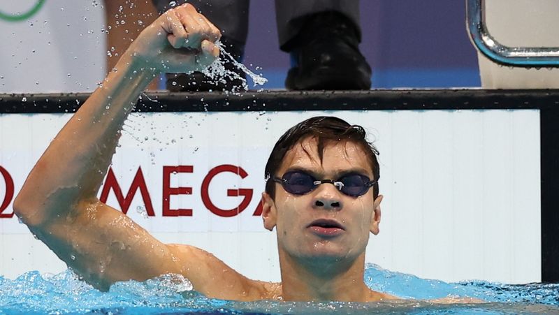 © Reuters. الروسي يفجيني ريلوف يحتفل بفوزه بذهبية في سباق 100 متر ظهرا للرجال في السباحة بألعاب طوكيو 2020 يوم الثلاثاء. تصوير: كاي فافنباخ - رويترز.