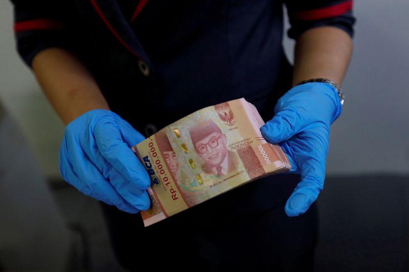 &copy; Reuters. FILE PHOTO: An employee wears synthetic gloves as she counts Indonesia's rupiah banknotes at a currency exchange office amid the spread of coronavirus disease (COVID-19) in Jakarta, Indonesia, March 19, 2020. REUTERS/Willy Kurniawan