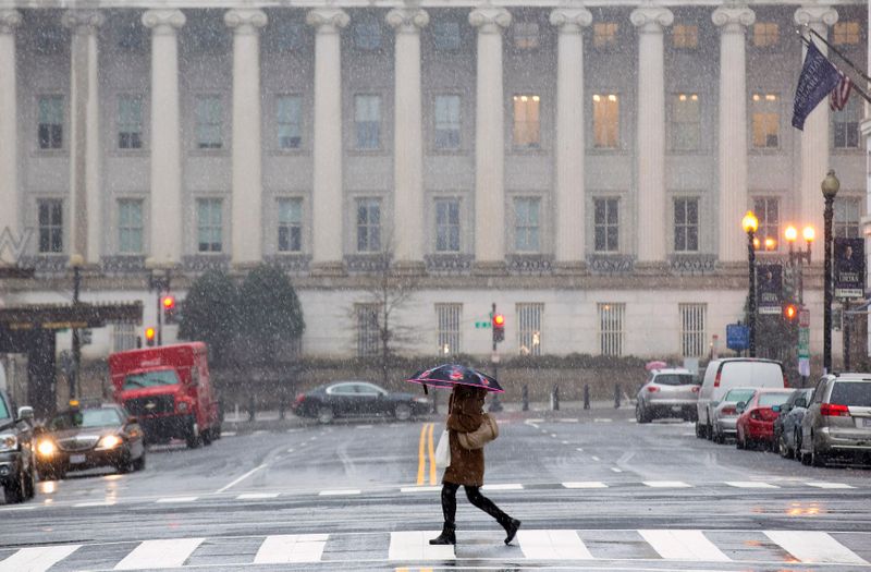 &copy; Reuters. A woman crosses a nearly empty street at rush hour, near the U.S. Treasury Building during a snow storm in Washington March 5, 2015. A large winter storm reaching from Texas to southern New England, which prompted school closings and led to almost 2,300 f