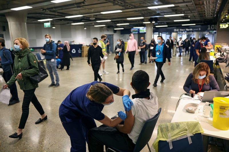 &copy; Reuters. FILE PHOTO: A person receives a dose of the Pfizer BioNTech COVID-19 vaccine at a mass vaccination centre for those aged 18 and over at the Tottenham Hotspur Stadium, amid the coronavirus disease (COVID-19) pandemic, in London, Britain, June 20, 2021. REU