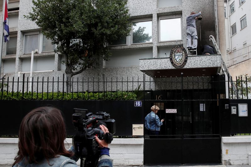 © Reuters. عامل يصلح أضرارا نجمت عن هجوم على سفارة كوبا في باريس يوم الثلاثاء. رويترز