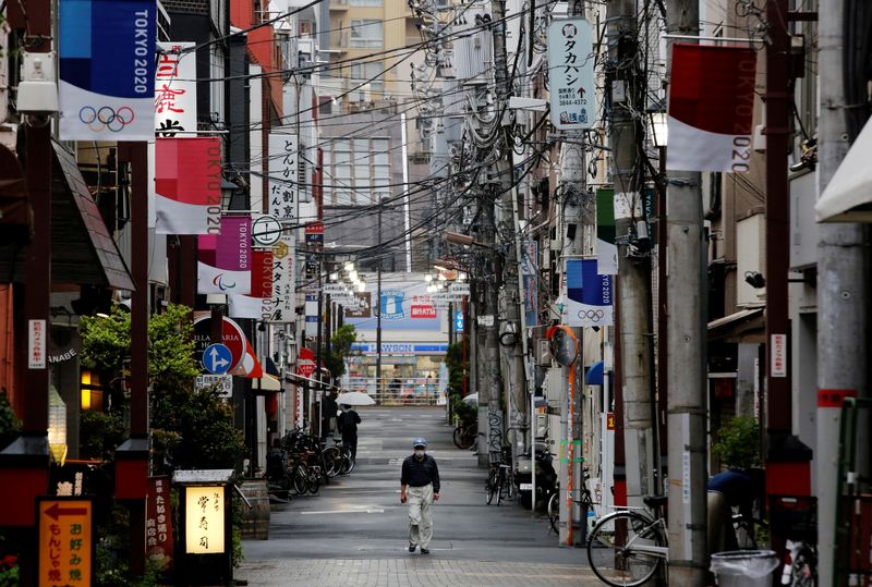 &copy; Reuters. Homem usando máscara caminha em rua decorada com bandeiras da Olimpíada Tóquio 2020 em Tóquio
07/05/2021 REUTERS/Kim Kyung-Hoon