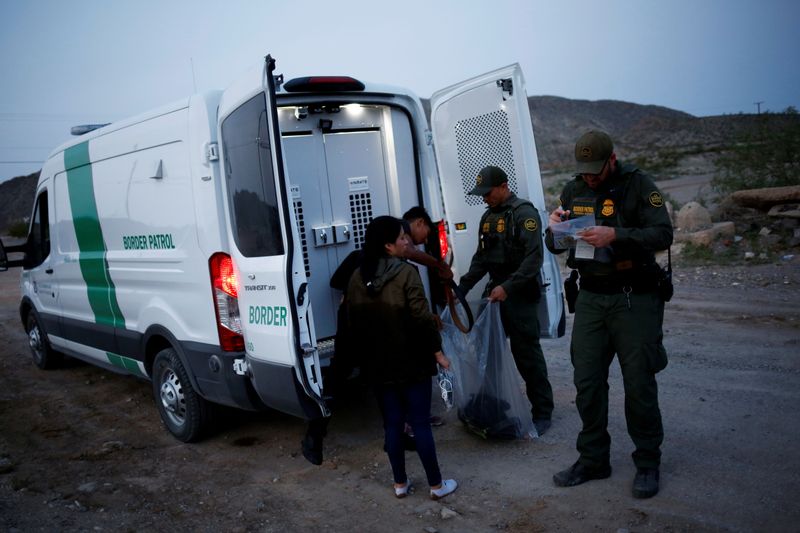 &copy; Reuters. FILE PHOTO: Migrants from Central America who were detained hand over their belongings to U.S. Border Patrol agents after crossing into the United States from Mexico, in Sunland Park, New Mexico, U.S., July 22, 2021. REUTERS/Jose Luis Gonzalez/File Photo