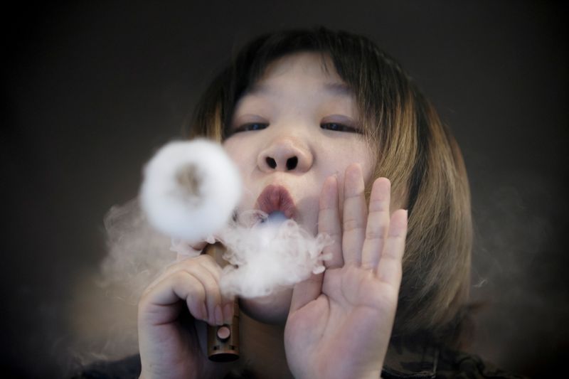 &copy; Reuters. FILE PHOTO: A saleswoman demonstrates vaping at the Vape Shop that sells e-cigarette products in Beijing, China January 30, 2019. REUTERS/Thomas Peter