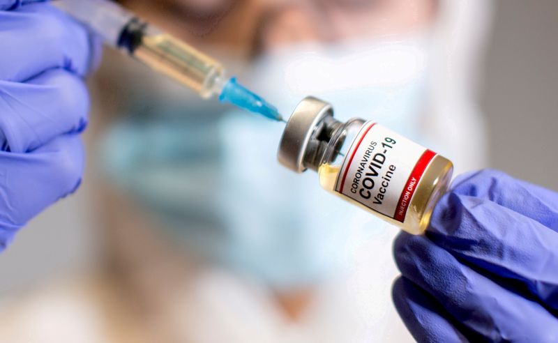 &copy; Reuters. Mulher segura recipiente com adesivo Vacina Covid-19, em imagem de ilustração
30/10/2020
REUTERS/Dado Ruvic
