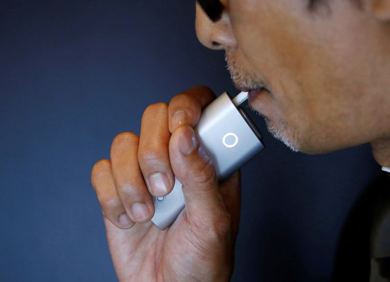 &copy; Reuters. FILE PHOTO: A staffer of British American Tobacco Japan demonstrates its new tobacco heating system device 'glo' after a news conference in Tokyo, Japan, November 8, 2016. REUTERS/Kim Kyung-Hoon/File Photo