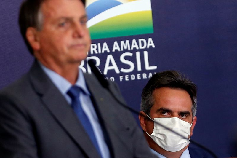 &copy; Reuters. Presidente Jair Bolsonaro é observado por Ciro Nogueira durante cerimônia no Palácio do Planalto
27/07/2021 REUTERS/Adriano Machado