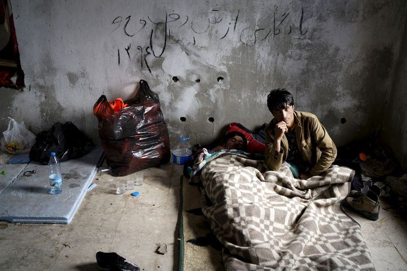 &copy; Reuters. Profughi afgani in attesa di partire per l'isola greca di Chio presso una casa abbandonata nei pressi della città costiera di Cesme, Turchia, 6 marzo 2016 REUTERS/Umit Bektas
