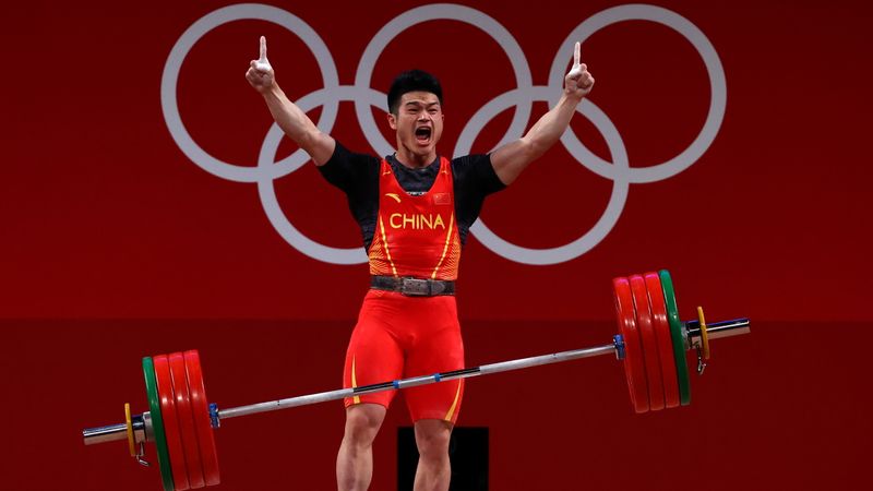 © Reuters. الرباع الصيني شي تشيونغ الفائز بذهبية وزن 73 كيلوجراما في رفع الأثقال يحتفل بنجاحه خلال مشاركته في أولمبياد طوكيو 2020 يوم الأربعاء. تصوير: إرجارد جاريدو - رويترز.
