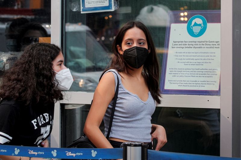 &copy; Reuters. People wear masks against the coronavirus disease (COVID-19), following the CDC recommendation that fully vaccinated Americans wear masks as the highly transmissible Delta variant has led to a surge in infections, as they enter the Disney Store in Times S