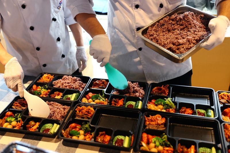© Reuters. FOTO DE ARCHIVO. Imagen referencial de cocineros enviados desde Corea del Sur preparando comidas en caja para los atletas del país en los Juegos Olímpicos de Tokio 2020 en un hotel en Urayasu, Prefectura de Chiba, Japón. 26 de julio de 2021. REUTERS/Kim Kyung-hoon