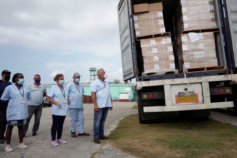 &copy; Reuters. Operatori sanitari guardano un carico di siringhe donate dalla comunità cubana negli Stati Uniti, a L'Avana, Cuba, 23 luglio 2021. REUTERS/Alexandre Meneghini
