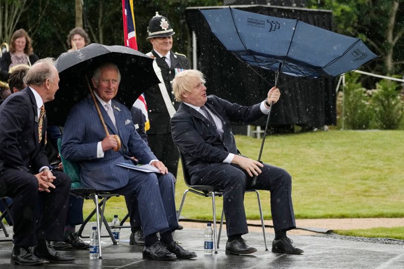 &copy; Reuters. Britain's Prince Charles looks on as Prime Minister Boris Johnson opens his umbrella at the National Memorial Arboretum in Staffordshire, Britain July 28, 2021. Christopher Furlong/Pool via REUTERS