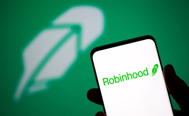 © Reuters. Robinhood logo is seen on a smartphone in front of a displayed same logo in this illustration taken, July 2, 2021. REUTERS/Dado Ruvic/Illustration