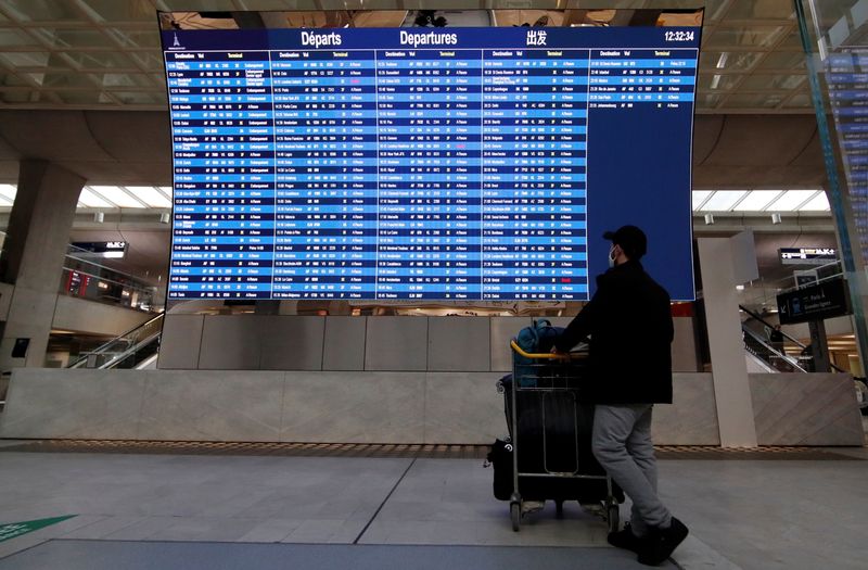 &copy; Reuters. FILE PHOTO: A passenger looks at a departures board with cancelled flights from Paris to London and Bristol at Paris Charles de Gaulle airport in Roissy near Paris, amid the spread of the coronavirus disease (COVID-19) in France, December 21, 2020. REUTER
