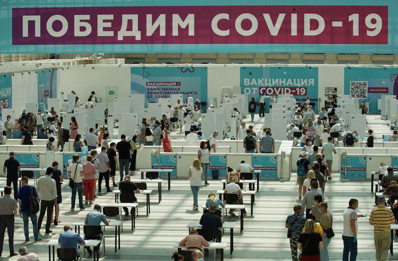 &copy; Reuters. People wait to receive a vaccine against the coronavirus disease (COVID-19) at a vaccination centre in Gostiny Dvor in Moscow, Russia July 6, 2021. The banner reads: "Let's defeat COVID-19" REUTERS/Tatyana Makeyeva