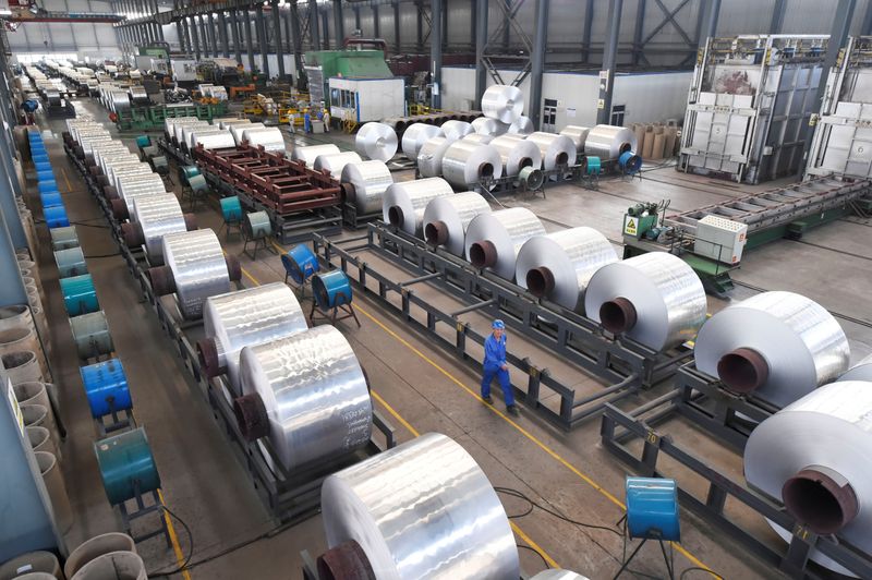 &copy; Reuters. Imagen de archivo de trabajadores junto a rollos de aluminio en una planta en Binzhou, provincia de Shandong, China. 13 de septiembre, 2018. REUTERS/Stringer/Archivo