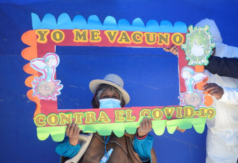 &copy; Reuters. A woman who had previously received a vaccine against the coronavirus disease (COVID-19) is asked to hold a frame reading "I am vaccinated against COVID-19," in Uru Chipaya, Bolivia July 23, 2021.  REUTERS/Claudia Morales
