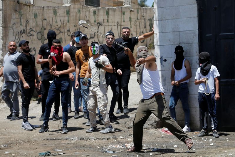 &copy; Reuters. فلسطينيون يرشقون قوات إسرائيلية بالحجارة بالقرب من الخليل بالضفة الغربية المحتلة يوم الخميس. تصوير: موسى قواسمة - رويترز. 