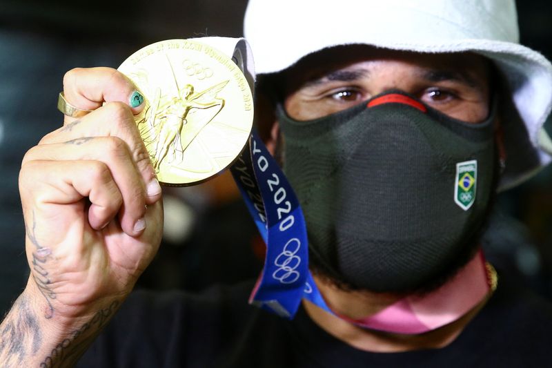 &copy; Reuters. Ítalo Ferreira mostra medalha de ouro na chegada ao Brasil
 29/7/ 2021   REUTERS/Carla Carniel