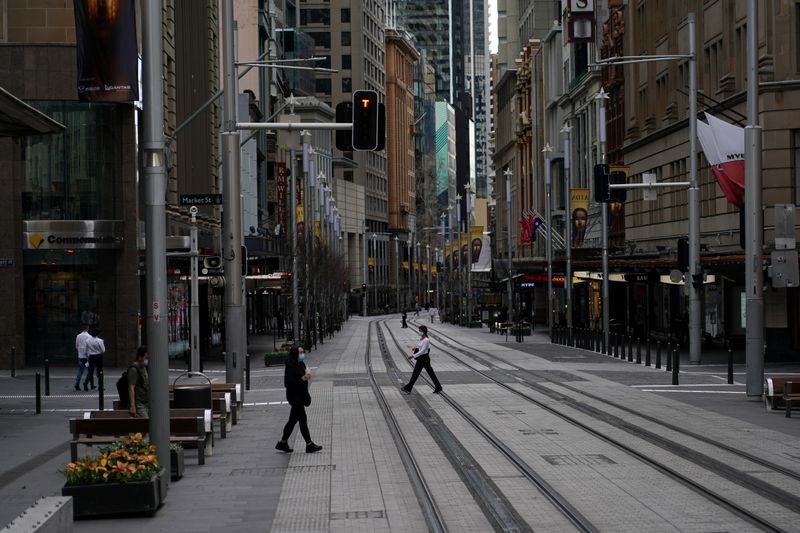 © Reuters. People in protective face masks walk through the quiet city centre during a lockdown to curb the spread of a coronavirus disease (COVID-19) outbreak in Sydney, Australia, July 28, 2021.  REUTERS/Loren Elliott