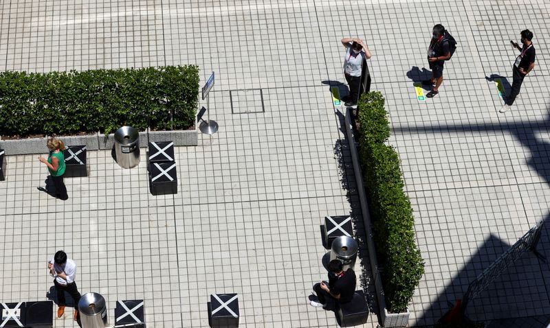 &copy; Reuters. FILE PHOTO: Smokers wait their turn in a queue as they observe social distancing, during a smoke break ahead of the Tokyo 2020 Olympic Games that were postponed to 2021 due to the coronavirus disease (COVID-19) pandemic, in Tokyo, Japan July 22, 2021. REU