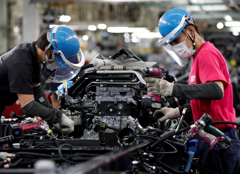 &copy; Reuters. Employees wearing protective face masks and face guards work on the automobile assembly line as the maker ramps up car production with new security and health measures as a step to resume full operations, during the outbreak of the coronavirus disease (CO