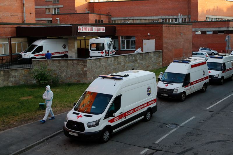 &copy; Reuters. A medical specialist wearing protective gear walks next to ambulances parked outside the Pokrovskaya hospital amid the outbreak of the coronavirus disease (COVID-19) in Saint Petersburg, Russia June 24, 2021.  REUTERS/Anton Vaganov