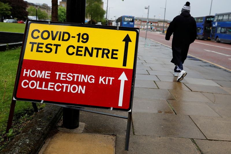 &copy; Reuters. FILE PHOTO: A man walks past a sign directing people to a testing station, amid the outbreak of the coronavirus disease (COVID-19) in Bolton, Britain, May 17, 2021. REUTERS/Phil Noble