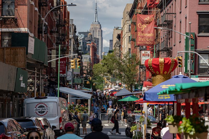 © Reuters. Pessoas caminham por rua com vários restaurantes no bairro de Little Italy, em Nova York
18/07/2021
REUTERS/Jeenah Moon