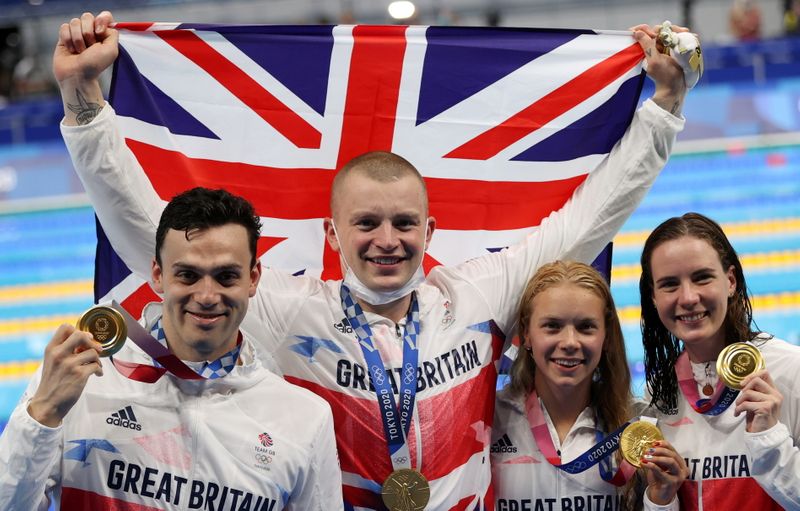 &copy; Reuters. Tokyo 2020 Olympics - Swimming - Mixed 4 x 100m Medley Relay - Medal Ceremony - Tokyo Aquatics Centre - Tokyo, Japan - July 31, 2021. Gold medallists James Guy of Britain, Adam Peaty of Britain, Anna Hopkin of Britain and Kathleen Dawson of Britain celebr