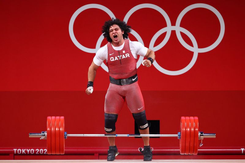 © Reuters. القطري فارس إبراهيم يحتفل بالفوز بذهبية وزن 96 كيلوجراما في رفع الأثقال في أولمبياد طوكيو يوم السبت. تصوير: إدجارد جاريدو - رويترز.