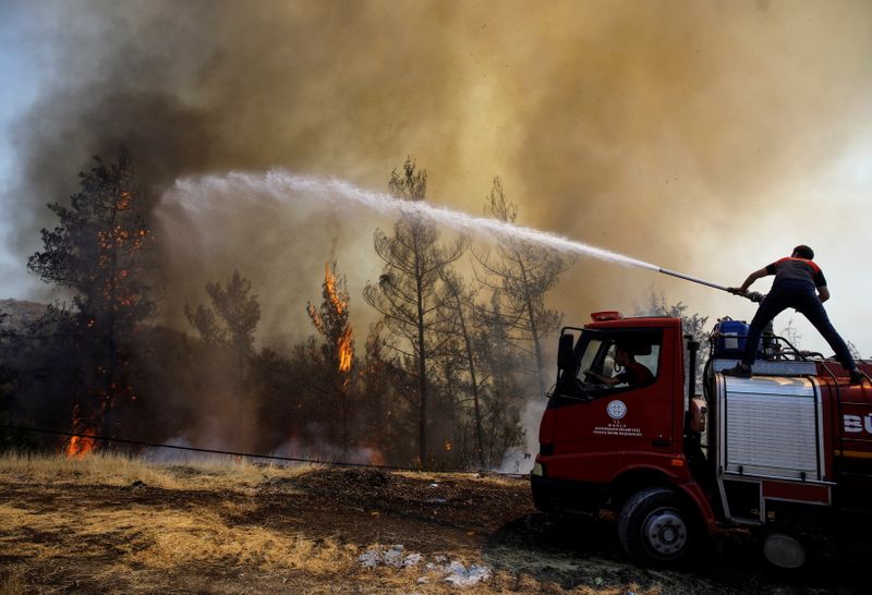 © Reuters. A firefighter tries to extinguish a wildfire near Marmaris, Turkey, August 1, 2021. REUTERS/Umit Bektas