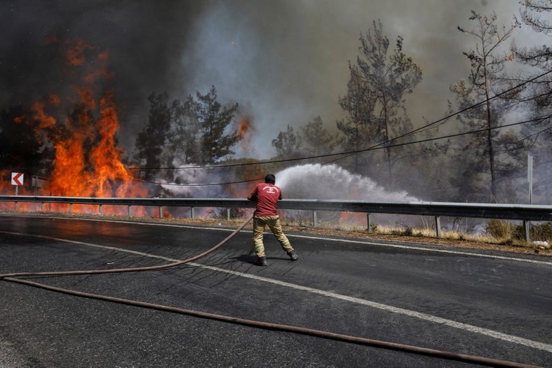 &copy; Reuters. Un bombero intenta extinguir parte de un incendio forestal cerca de Marmaris, en Turquía. Agosto 1, 2021. REUTERS/Umit Bektas