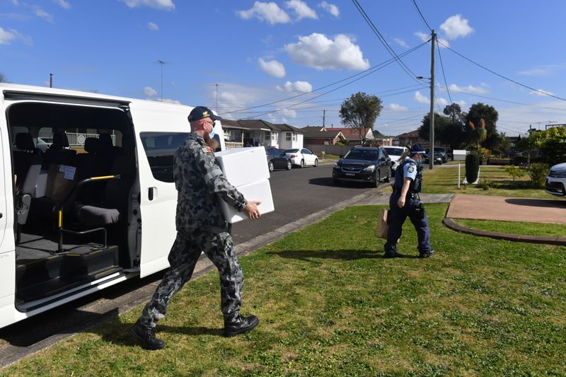 © Reuters. Australian Defence Force personnel and NSW police deliver emergency food parcels for people in lockdown in the Fairfield suburb in the southwest of Sydney, Australia, August 2, 2021.  AAP Image/Mick Tsikas via REUTERS  