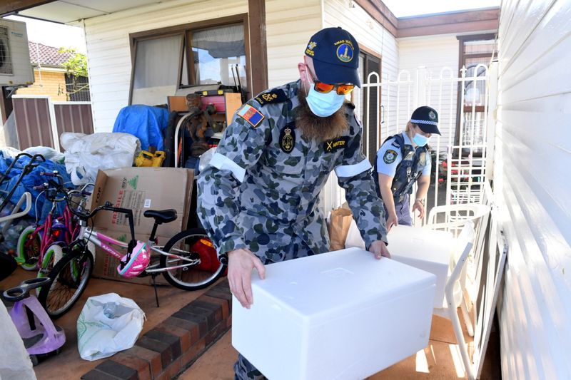 &copy; Reuters. Il personale dell'Australian Defense Force e la polizia del NSW consegnano pacchi alimentari di emergenza per le persone in isolamento nel sobborgo di Fairfield nel sud-ovest di Sydney, Australia, 2 agosto 2021. Immagine AAP/Mick Tsikas tramite REUTERS  
