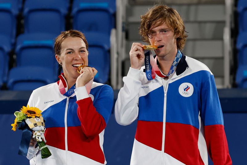 &copy; Reuters. Aug 1, 2021; Tokyo, Japan; (L-R) Anastasia Pavlyunchenkova and Andrey Rublev (both of ROC) celebrate with their gold medals during the medals ceremony after their match against Elena Vesnina and Aslan Karatsev (not pictured, both of ROC) in the mixed doub