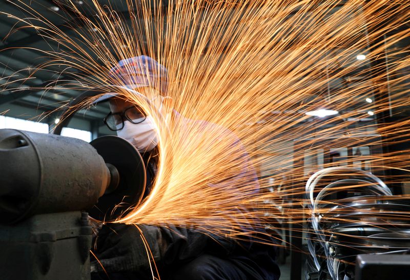 &copy; Reuters. FOTO DE ARCHIVO: Un trabajador con mascarilla trabaja en una línea de producción fabricando llantas de acero para bicicletas en una fábrica en Hangzhou, provincia de Zhejiang, China, 2 de marzo de 2020. REUTERS/China Daily