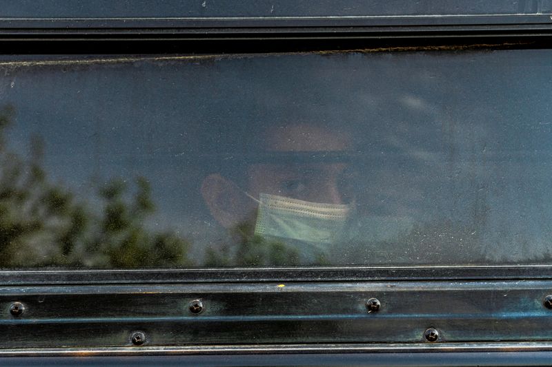 &copy; Reuters. FILE PHOTO: A young asylum-seeking migrant looks out from the window on a bus while waiting to be transported by the U.S. Border Patrols after crossing the Rio Grande river into the United States from Mexico in La Joya, Texas, U.S., March 26, 2021.  REUTE