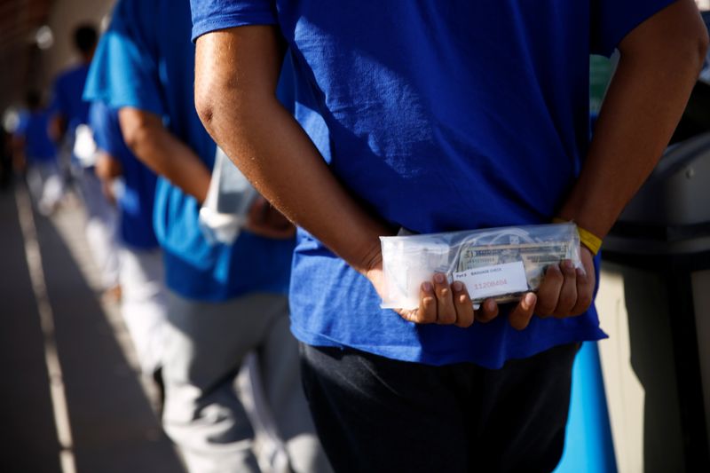 &copy; Reuters. Foto de archivo. Un migrante expulsado de Estados Unidos y enviado a México bajo el Título 42 lleva sus pertenencias en una bolsa mientras cruza la frontera en Ciudad Juarez, México, julio 29, 2021. REUTERS/Jose Luis Gonzalez