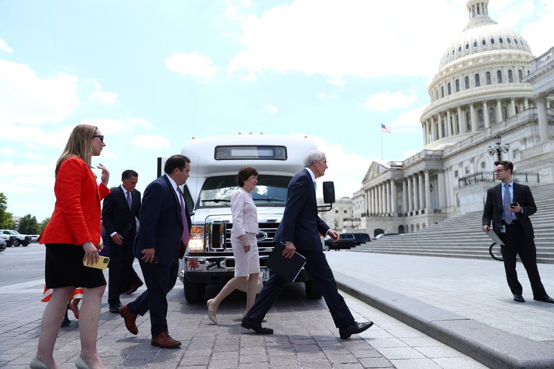 &copy; Reuters. FILE PHOTO: Senators walk off a bus following a meeting with U.S. President Joe Biden at the White House regarding an infrastructure bill, on Capitol Hill in Washington, U.S., June 24, 2021.  REUTERS/Tom Brenner