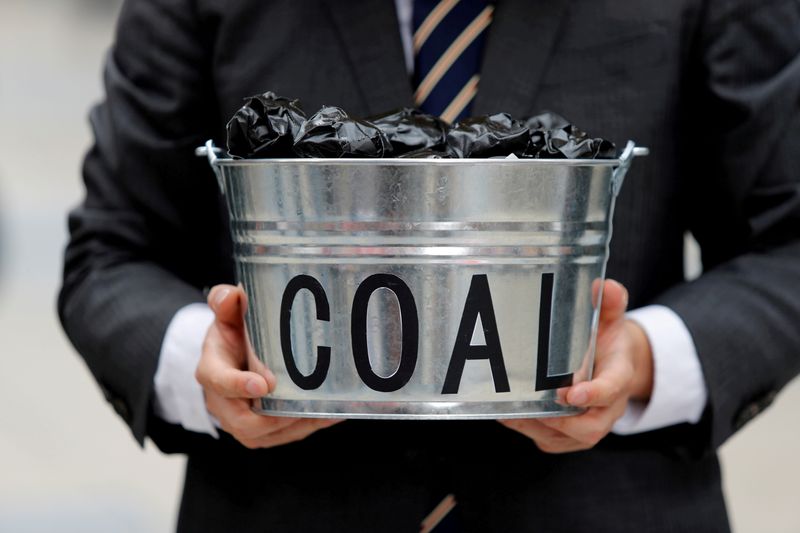 © Reuters. FILE PHOTO: A protester holds a bucket of coal during a demonstration demanding Japan to stop supporting coal at home and overseas, at the G20 Summit in Osaka, Japan, June 28, 2019. REUTERS/Jorge Silva/File Photo