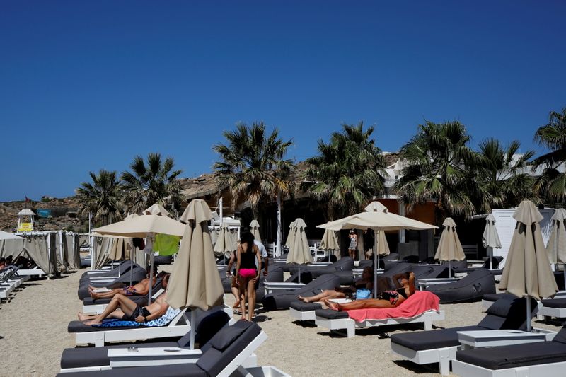 &copy; Reuters. FILE PHOTO: People lay on sunbeds at the Tropicana beach bar in Paradise beach on the island of Mykonos, Greece, July 18, 2021. REUTERS/Louiza Vradi/File Photo