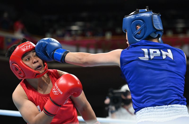 © Reuters. 　８月３日、女子ボクシングフェザー級の入江聖奈は３日、東京五輪の決勝でネストイ・ペテシオ（フィリピン）を５━０の判定で下し、金メダルを獲得した。写真はペテシオを攻める入江。両国国技館で代表撮影（２０２１年　ロイター）