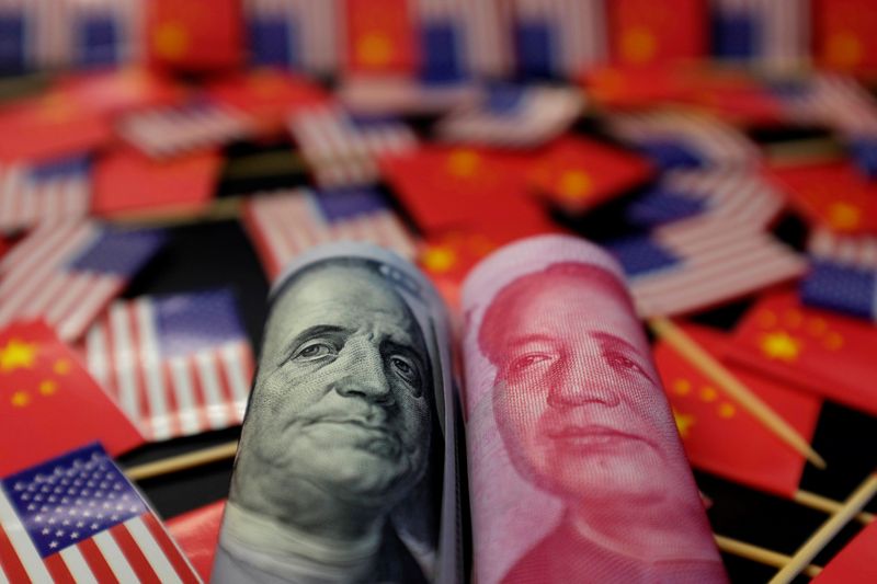 &copy; Reuters. A U.S. dollar banknote featuring American founding father Benjamin Franklin and a China's yuan banknote featuring late Chinese chairman Mao Zedong are seen among U.S. and Chinese flags in this illustration picture taken May 20, 2019. Picture taken May 20,
