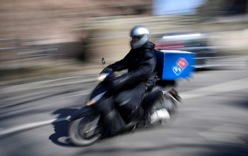 &copy; Reuters. A Dominoes pizza delivery driver rides a motorbike in a residential street in West London as the spread of the coronavirus disease (COVID-19) continues, in London, Britain, March 24, 2020. REUTERS/Toby Melville/File Photo