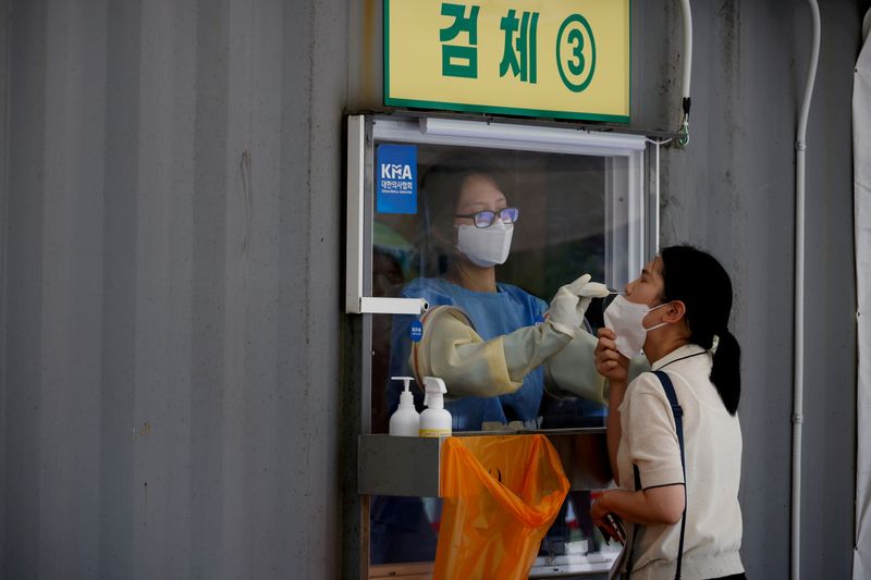 &copy; Reuters. موظفة صحة تأخذ مسحة من فتاة لإجراء اختبار للإصابة بفيروس كورونا في سول عاصمة كوريا الجنوبية يوم 15 يوليو تموز 2021. تصوير: كيم هونج-جي - رويترز.