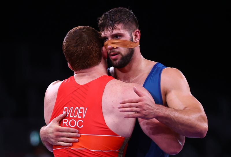 &copy; Reuters. Tokyo 2020 Olympics - Wrestling - Greco-Roman - Men's 97kg - Quarterfinal - Makuhari Messe Hall A, Chiba, Japan - August 2, 2021. Musa Evloev of the Russian Olympic Committee and Alex Gergo Szoke of Hungary hug REUTERS/Leah Millis